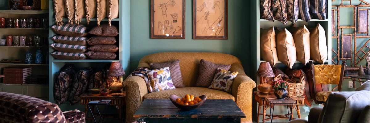 Emporium 23 boutique showroom in Newton NC featuring artisan home décor with pillows, mugs, and cozy seating.