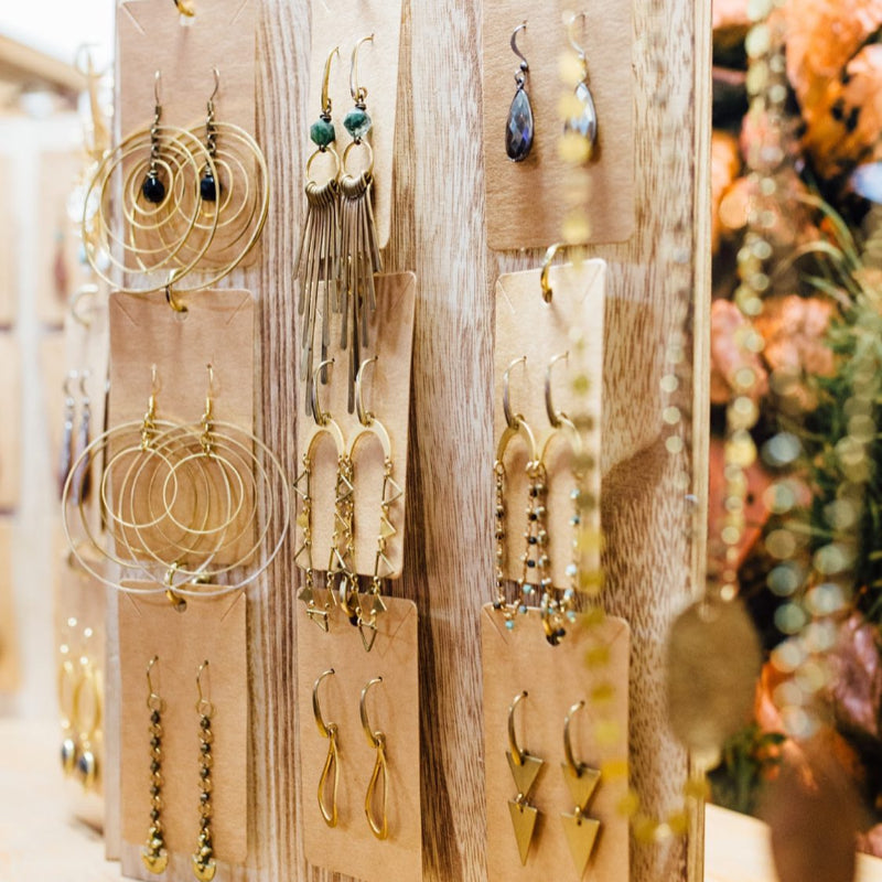 Display of artisan handmade earrings including gold hoops, drop earrings, and unique designs – boutique jewelry collection at Emporium 23.