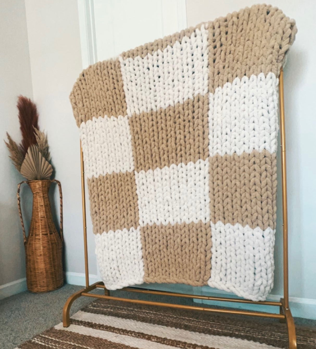 Handmade cozy corner chunky knit blanket draped on a sofa