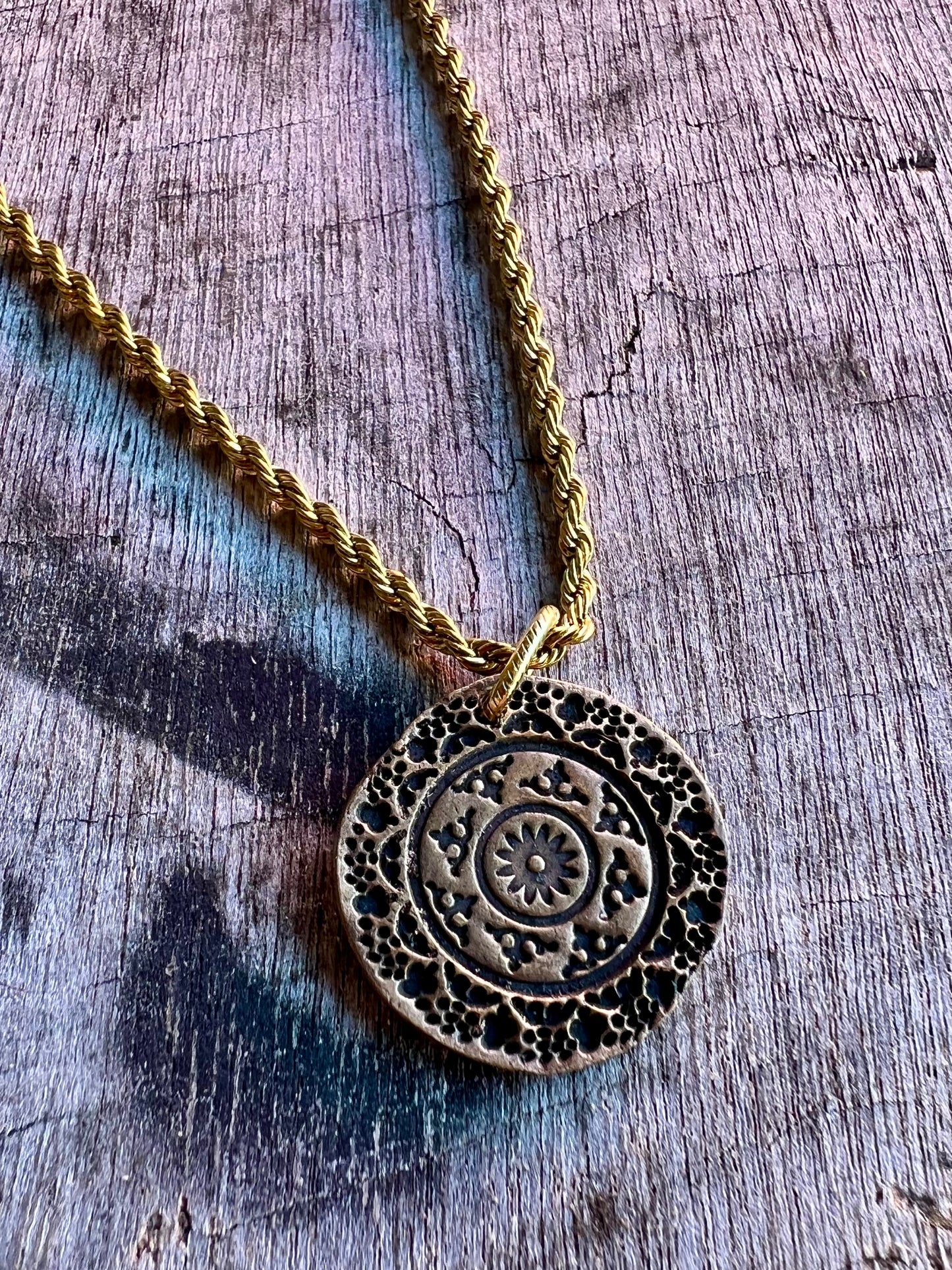 Round medallion pendant necklace with intricate detail
