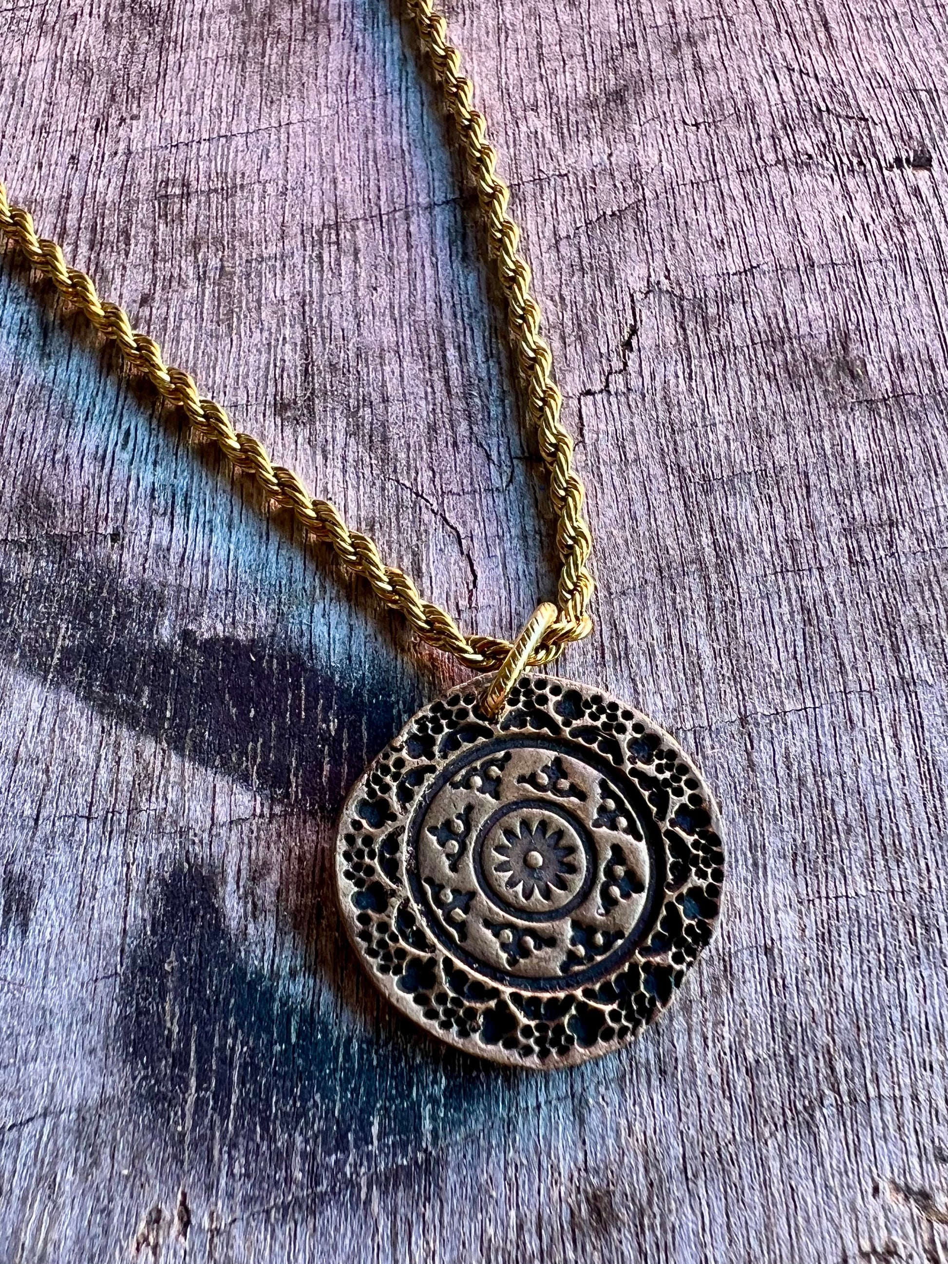 Round medallion pendant necklace with intricate detail