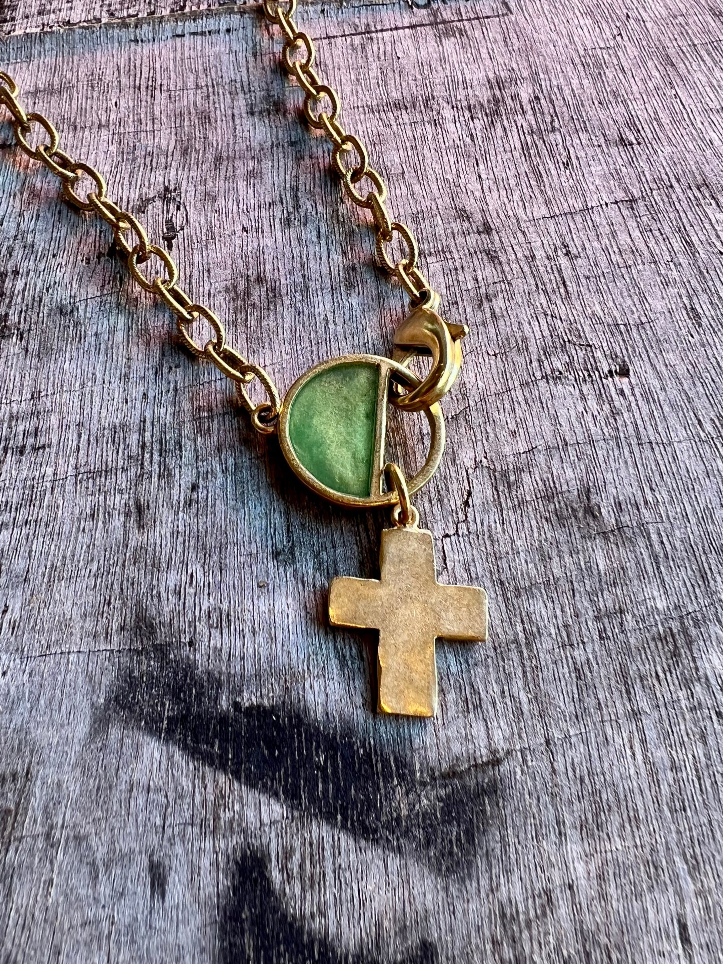 Cross pendant necklace with green accent stone